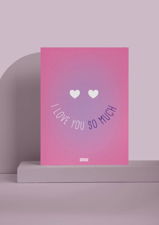 Carte avec un dégradé de rose avec un smiley au centre. Les yeux du smiley sont en forme de coeur, et la bouche est représentée par le texte "I love you so much". 