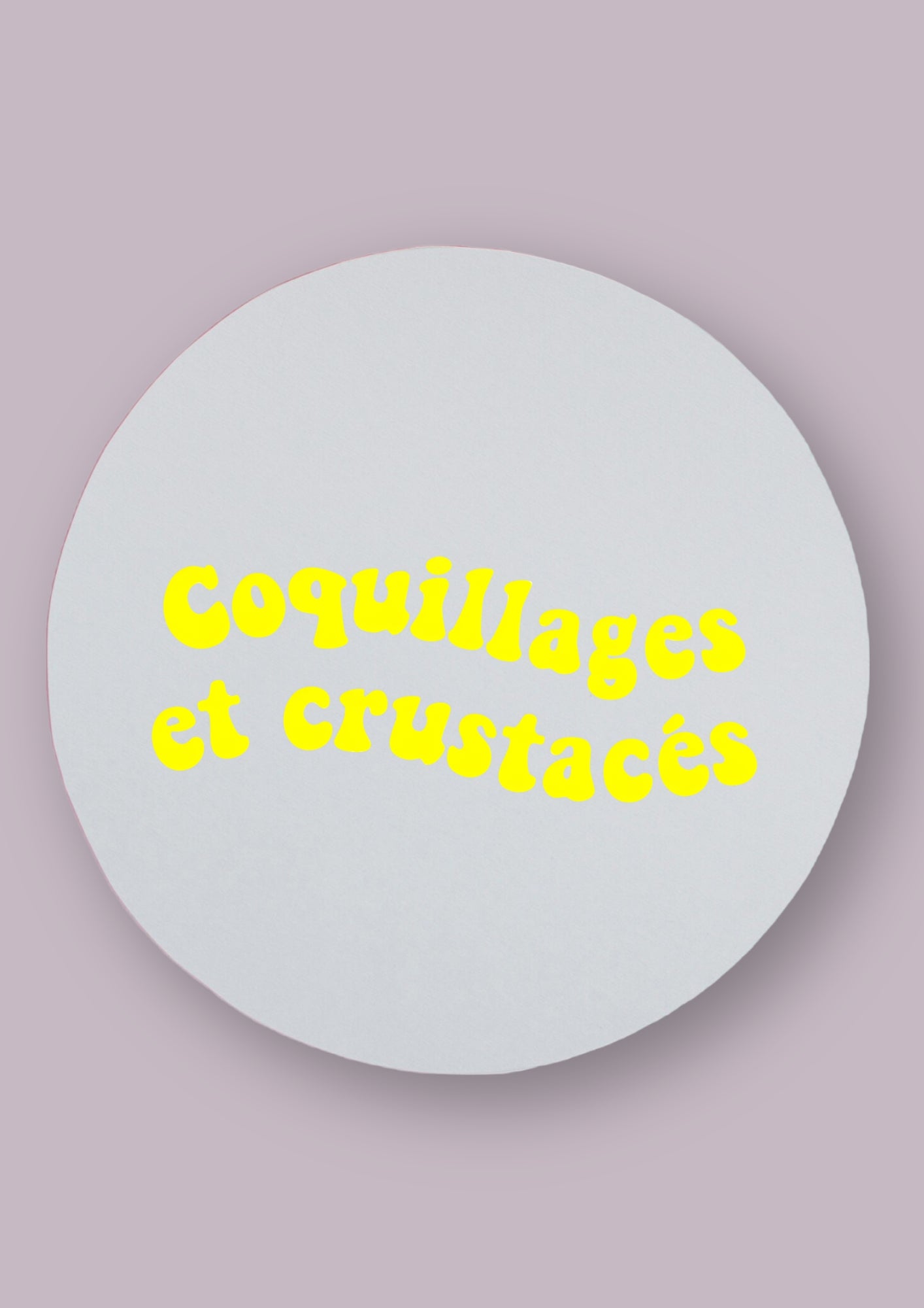Miroir rond sur fond neutre, avec la phrase coquillages et crustacés écrit dessus en jaune.   
