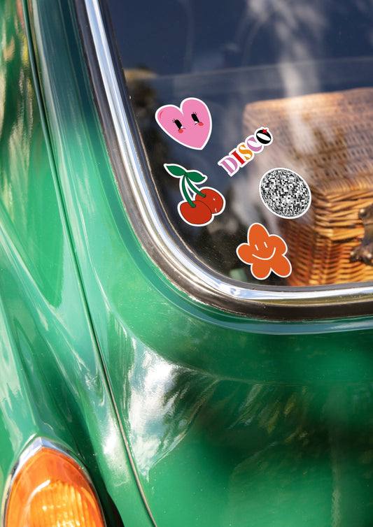 Pare brise arrière d'une voiture style fiat 500 avec cinq stickers collé dessus. 